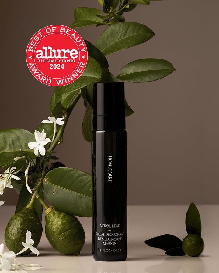 Best of Beauty Allure Award Winner Homecourt Room Deodorizer Neroli Leaf Fragrance next to Neroli branch leaves and fruit.