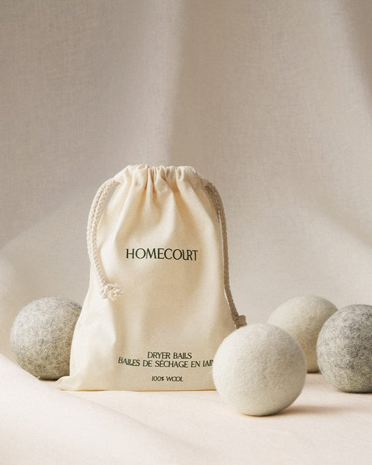Homecourt 100% wool laundry dryer ball set with bag on a neutral background.