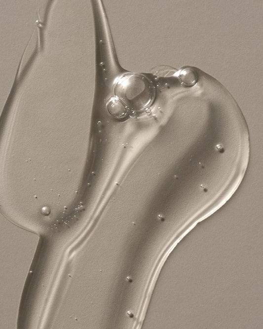Close-up of a smooth, grayish-brown liquid texture on a flat surface.