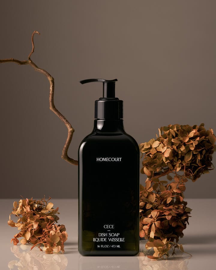 Black bottle of Homecourt Award-Winning Dish Soap on a neutral background with dried Cece flowers on a neutral background.