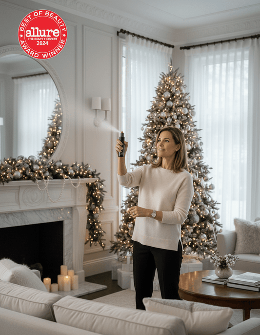 Women using Best of Beauty Allure Award Winner Homecourt Room Deodorizer in a home with Christmas tree and white couches.