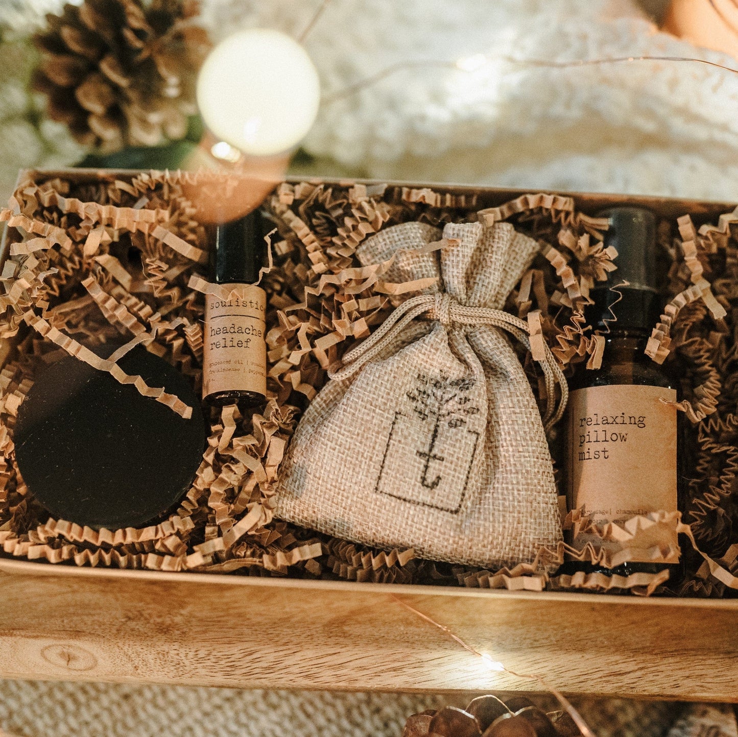 Therapeutic Travel Gift Set open with bottles and a drawstring bag on crinkled paper in a wooden box.