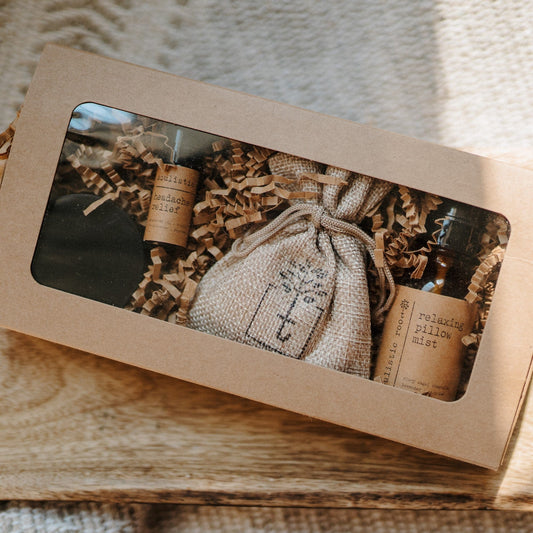 Therapeutic Travel Gift Set top view with a bag and bottles in a brown box on a wooden surface