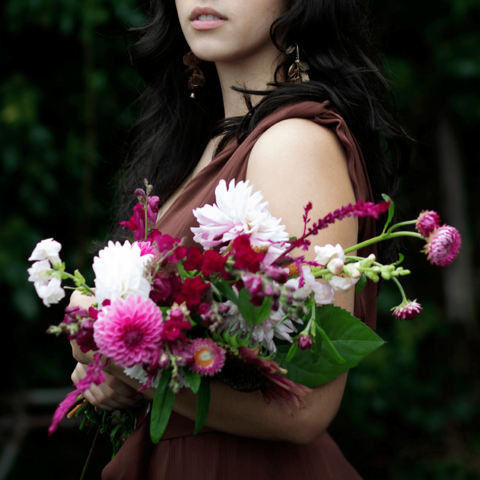 Teenage girl holding a bouquet of dahlias, strawflowers, roses and snapdragons grown & arranged by Little Mountain Flowers