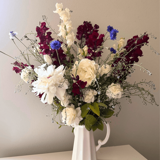 A 4th of July display of Peonies, roses, snapdragons, and blue bachelor button grown & arranged by Little Mountain Flowers