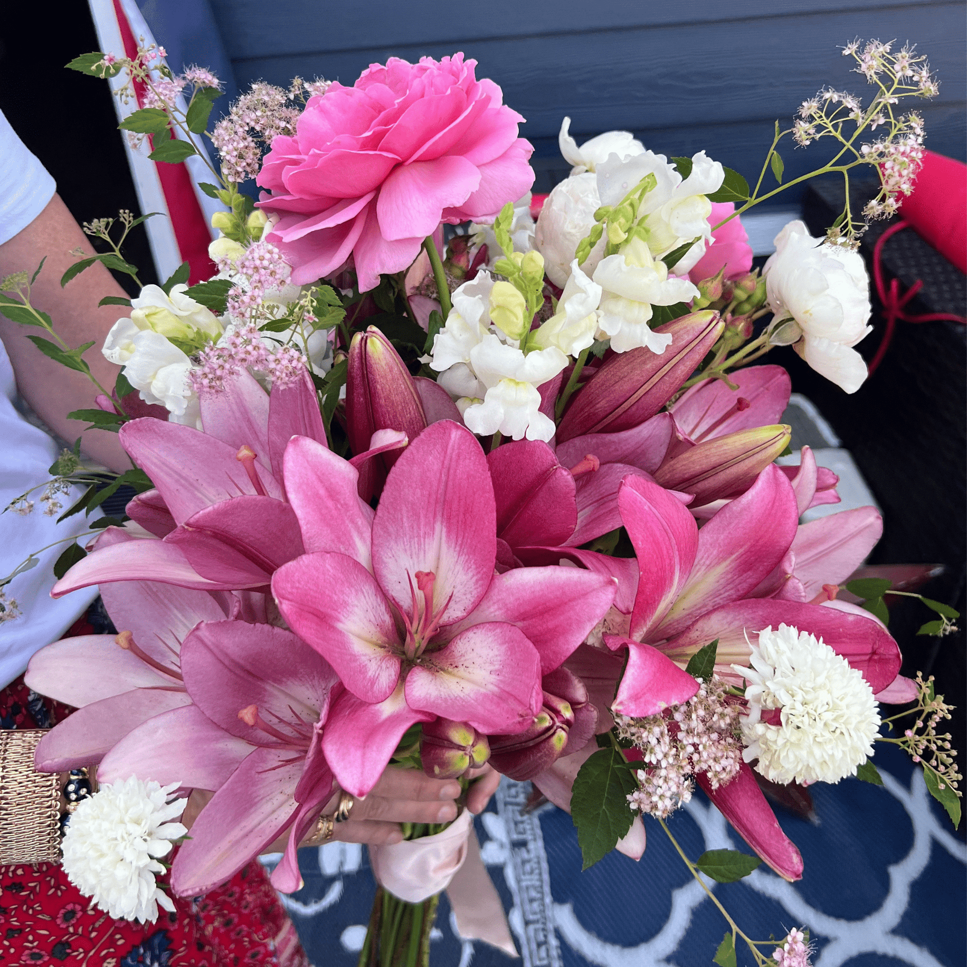 Women holding an arrangement of dahlias, roses, snapdragons, lilies and more grown & arranged by Little Mountain Flowers.